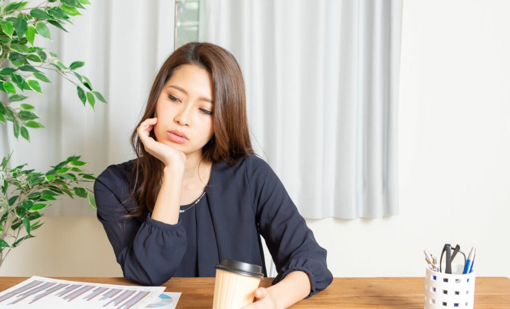 woman sitting at desk looking stressed and burned out
