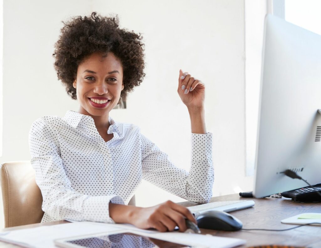 African American woman sitting at desk looking empowered as a leader